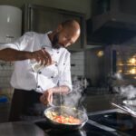 Auxiliar de Cozinha preparando alimentos em um Aeroporto do Rio, representando uma excelente oportunidade de emprego no setor de Refeições Coletivas